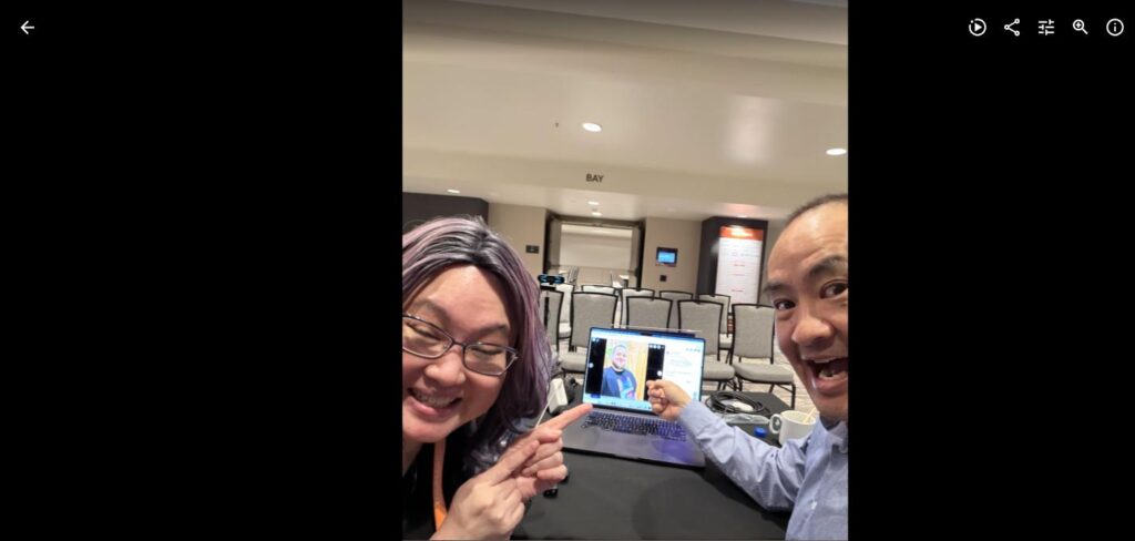 Liana Ling and Dennis Yu at DigiMarCon Toronto reviewing podcast content on a laptop