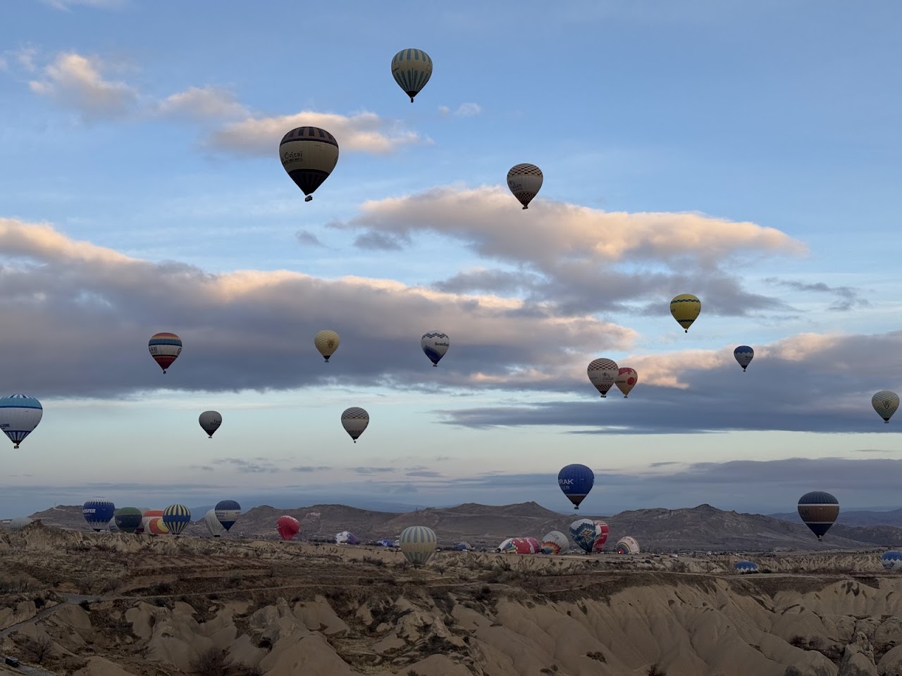 Hot air balloons floating over the Cappadocia landscape at dawn in Turkey