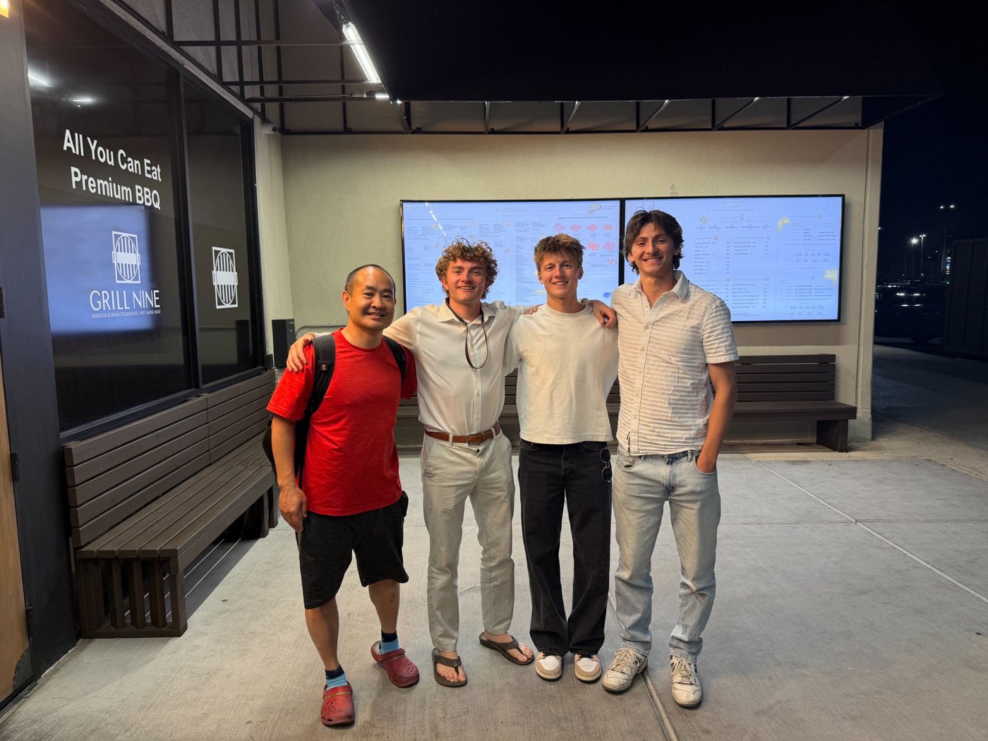 Dennis Yu in 2026, slimmer, with three young AI Builders at Grill Nine