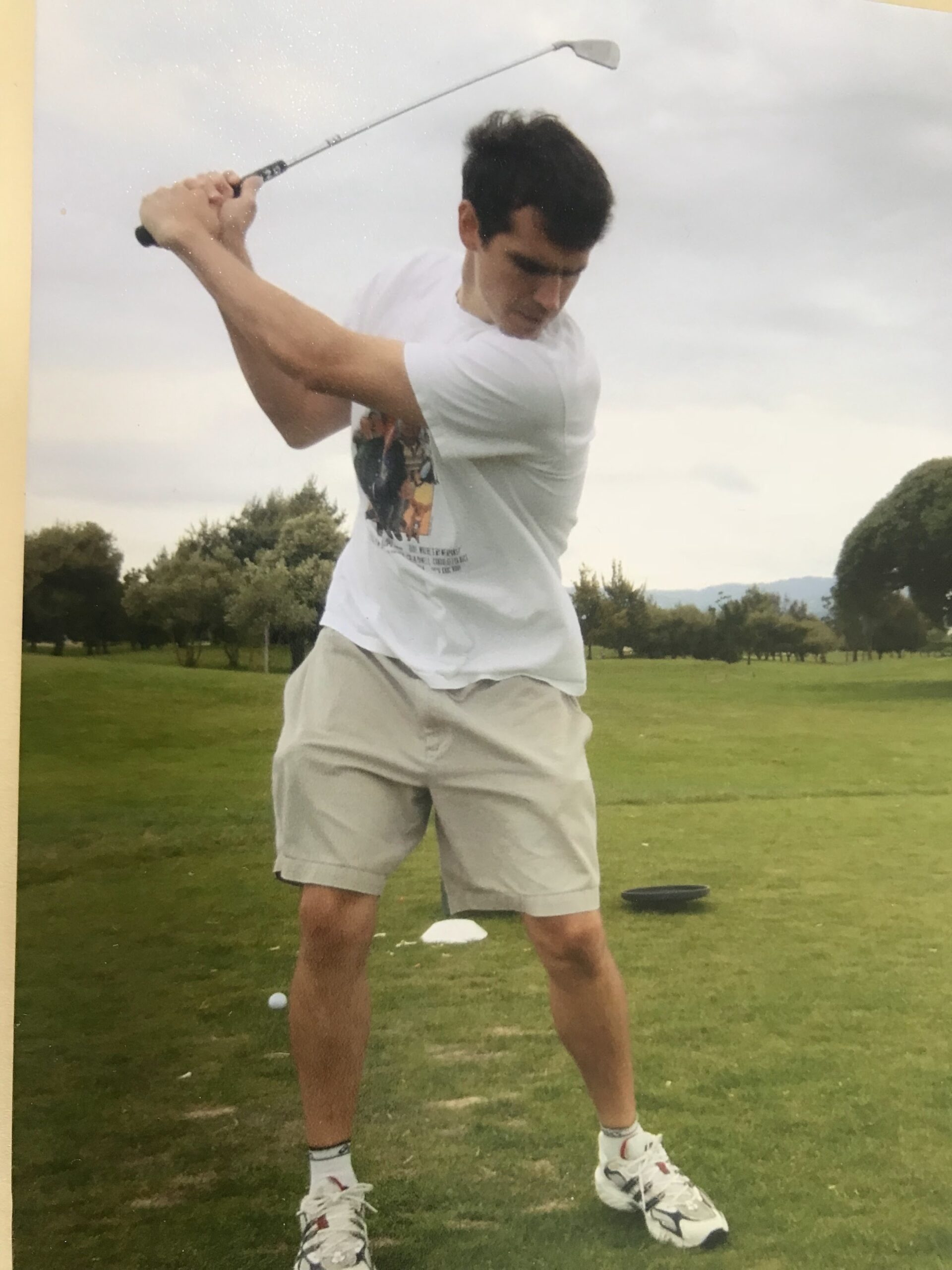 Chris Rummel at the top of a golf backswing, face down toward the ball
