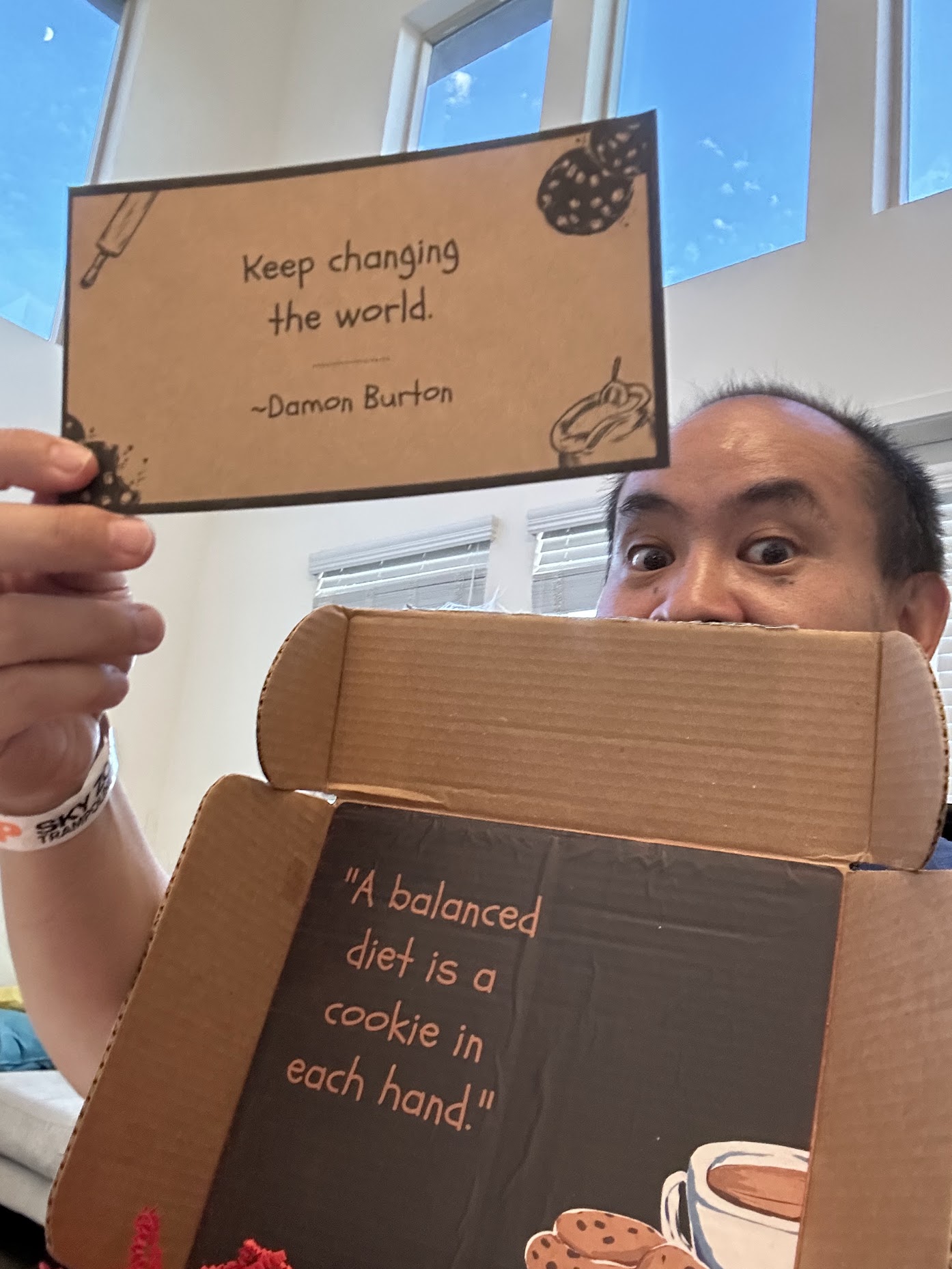 Dennis Yu holding Damon’s cookie gift box and a card that says Keep changing the world, Damon Burton