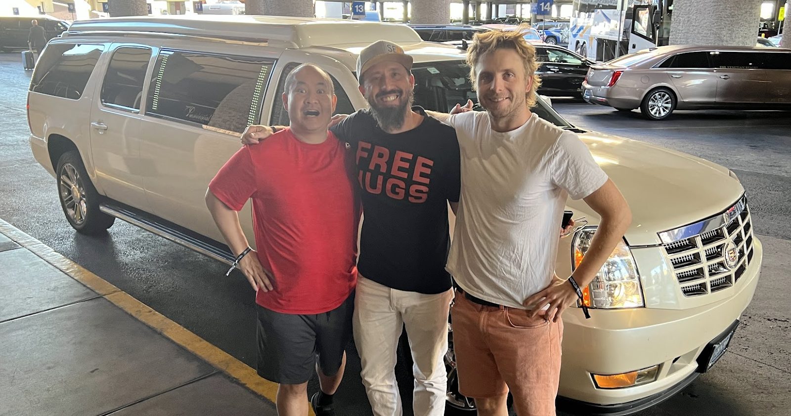 Dennis Yu, Damon Burton in a Free Hugs shirt, and Sam McLeod in front of Damon’s white Escalade limo at the airport