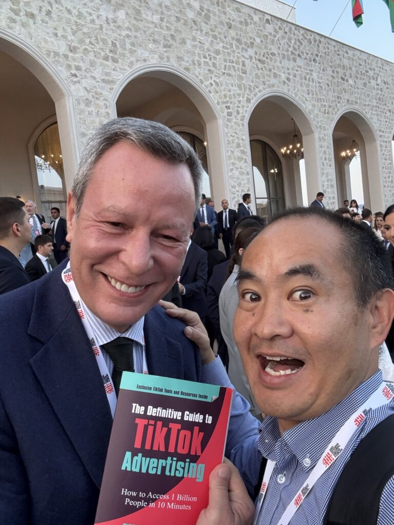 Dennis Yu at the Shusha Global Media Forum in Shusha, Azerbaijan, holding The Definitive Guide to TikTok Advertising