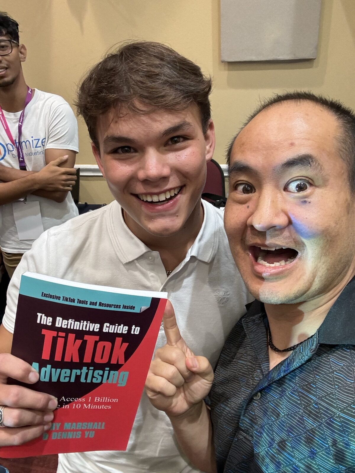 Conference attendee holding the TikTok book next to Dennis Yu