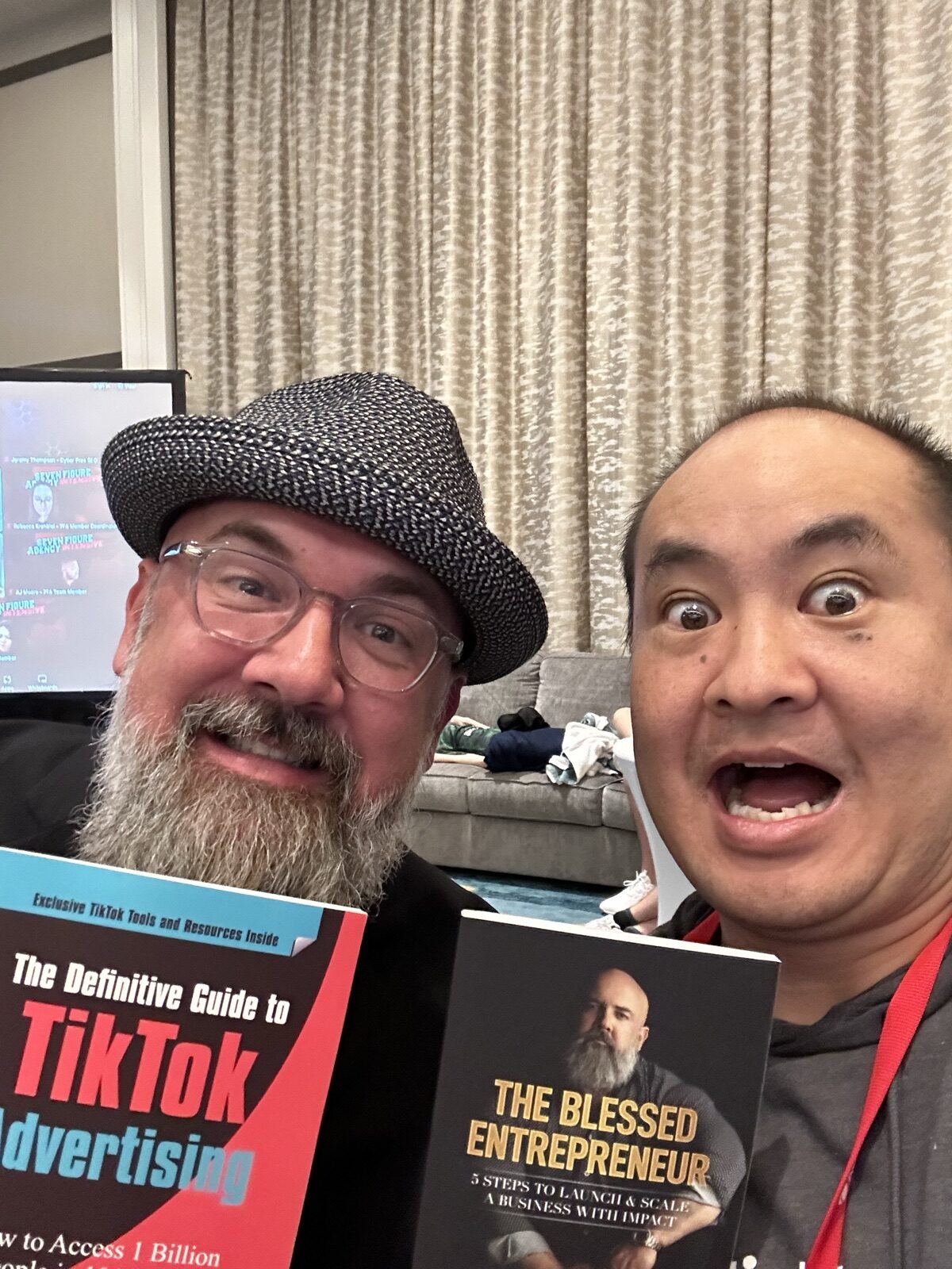 Two authors holding each other's books including The Definitive Guide to TikTok Advertising
