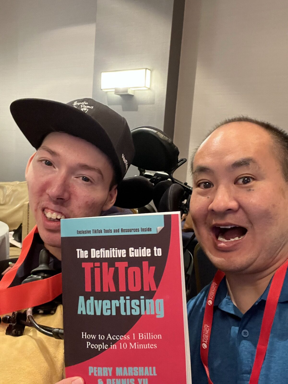 Dennis Yu and an attendee at Social Media Marketing World holding the TikTok book