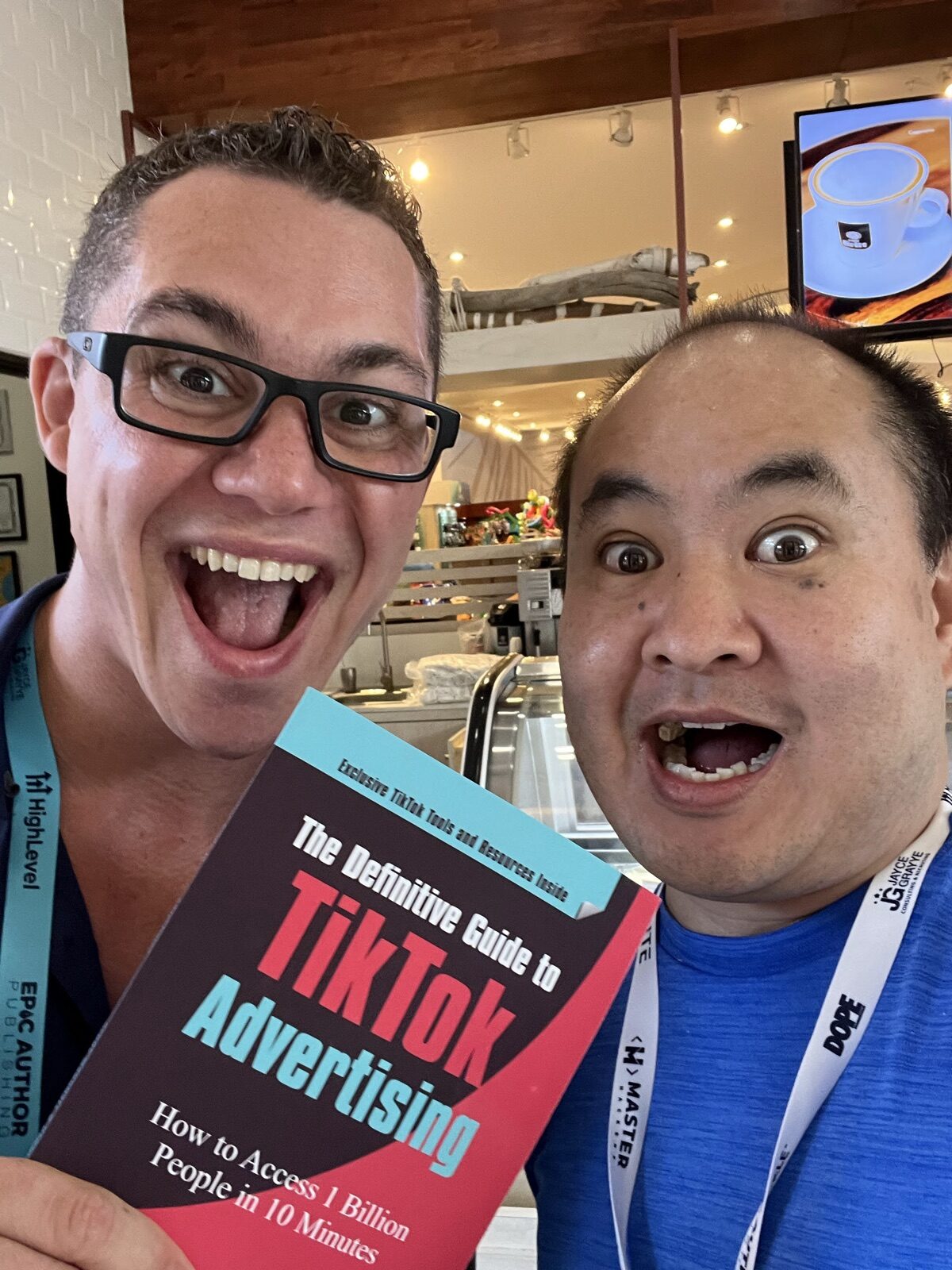 Dennis Yu and an attendee with HighLevel and Epic Author Publishing lanyards holding the TikTok book