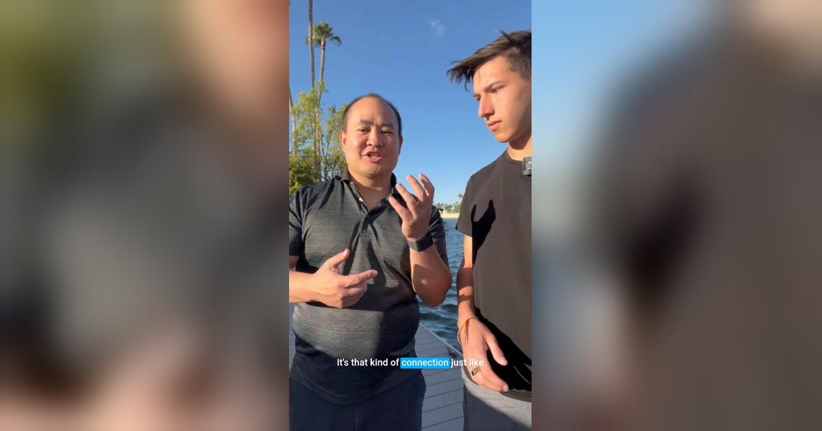 Dennis Yu gesturing on a Val Vista Lakes dock walk-and-talk with Britain Eriksen — action still for AI without being an engineer
