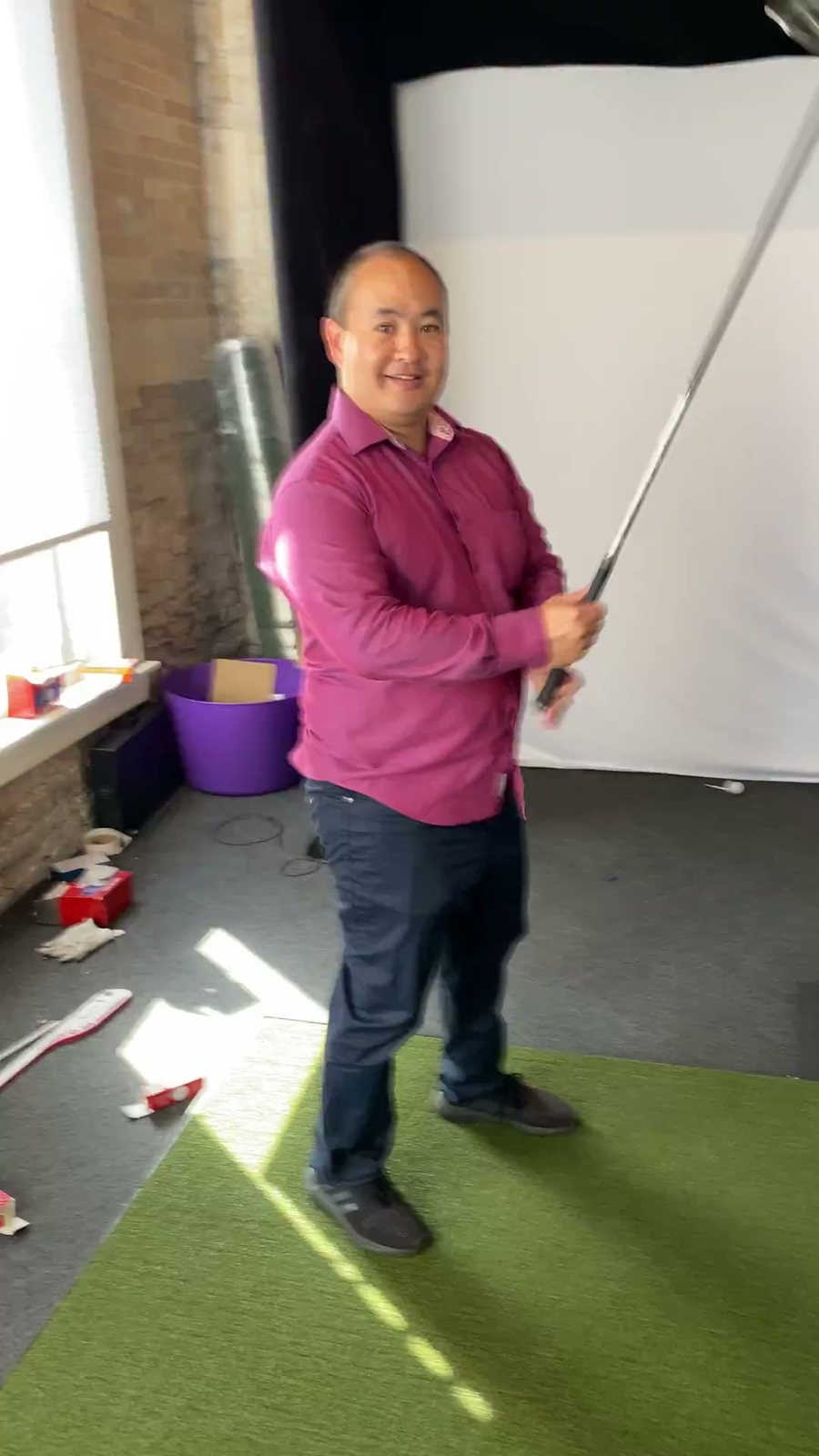 Dennis Yu swinging in a golf simulator, November 2021