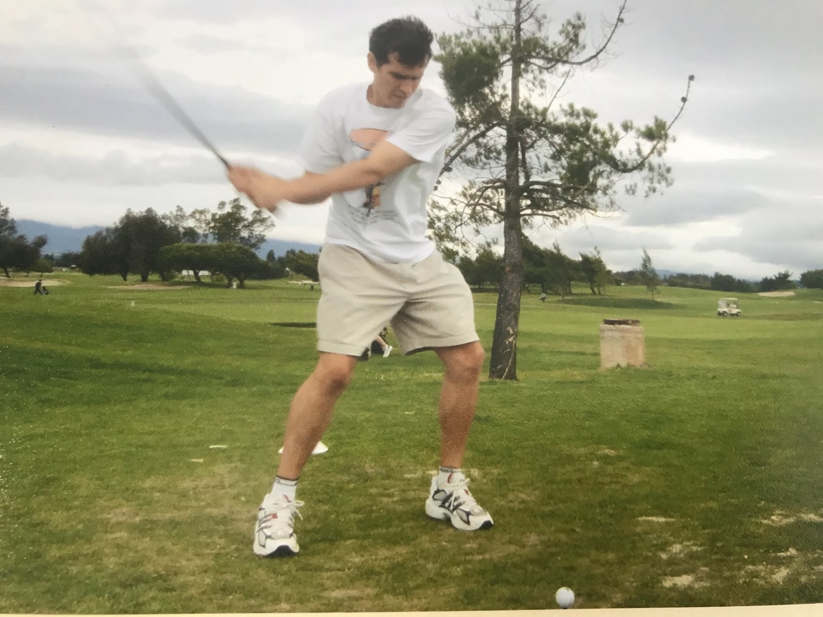 Young Dennis Yu at the top of his backswing in a white t-shirt, scanned print