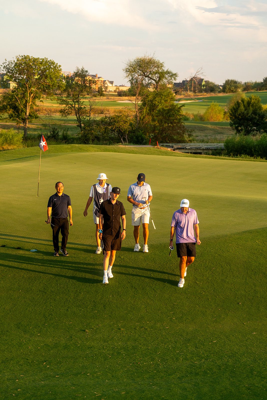 Dennis Yu, Simon Harries and Aden Trano walking to the green at Fields Ranch
